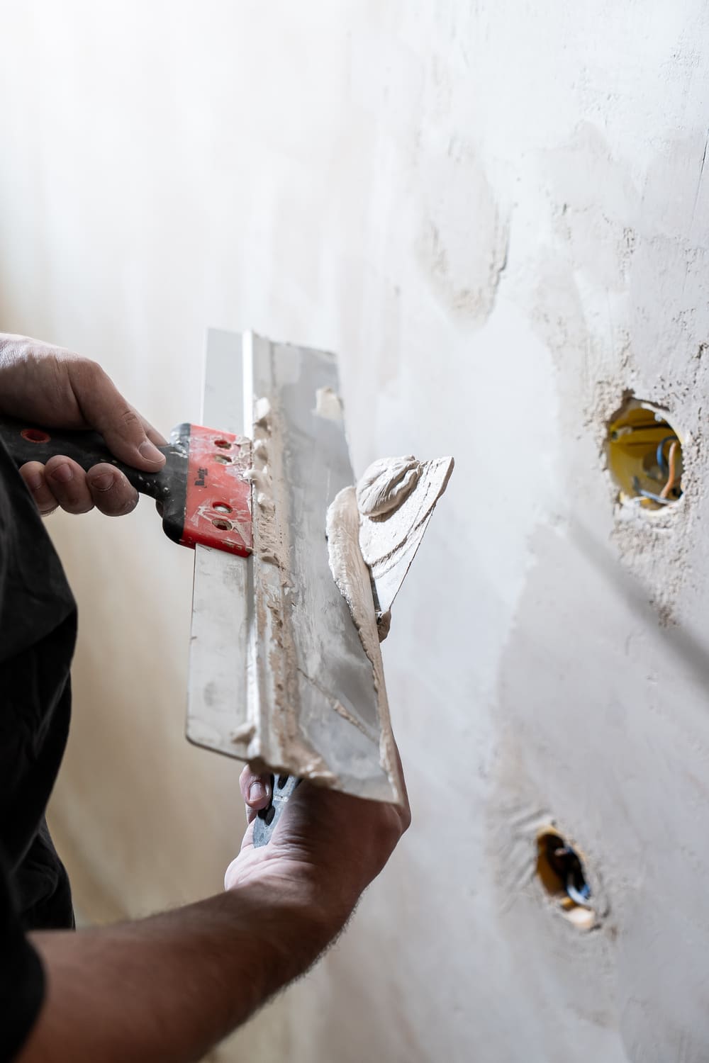happy-worker-man-making-wall-room-by-hand-spatula-repair